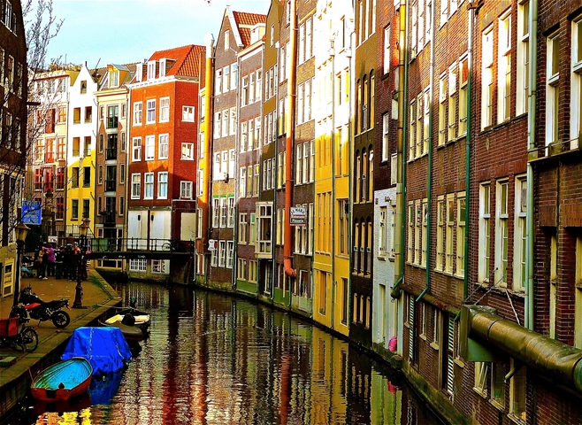 Canal lined with colorful buildings in Amsterdam.