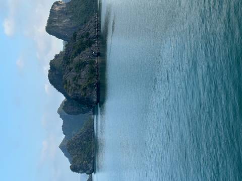       Serene channel of turquoise water winding between forested limestone islands
  
