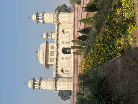       Ornate marble-inlay mausoleum of Itimad-ud-Daulah fronted by colorful flower beds.
  