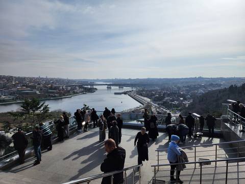       Observation deck overlooking a river and the city skyline with many visitors enjoying the view.
  