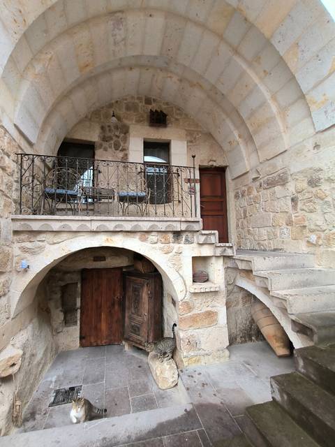       Stone staircase and arched balcony of a traditional cave-style hotel in Cappadocia.
  