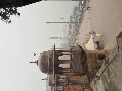       Mughal-style riverside pavilion overlooking misty ghats and boats on the Ganges.
  