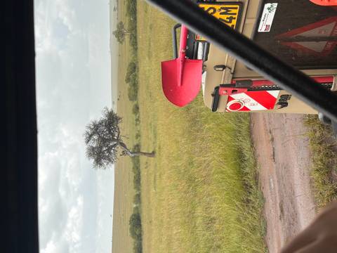       Interior frame of safari vehicle looking toward a single tree on open grassland.
  