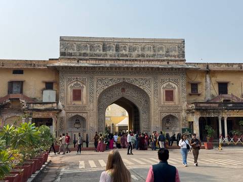       Ornate gateway of Jaipur’s City Palace complex with visitors entering the courtyard
  