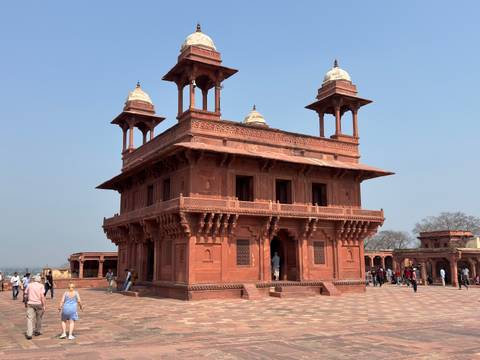       Red sandstone Diwan-i-Khas pavilion at Fatehpur Sikri against a clear blue sky
  