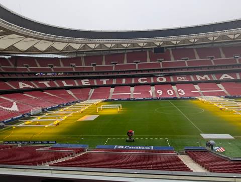       Panoramic view inside Atlético de Madrid’s stadium with grow lights on the pitch.
  