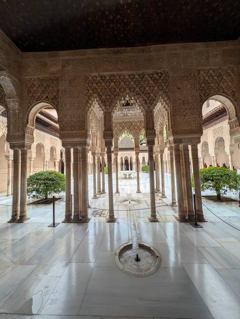       Intricately carved Moorish arches surround the reflective Court of the Lions.
  