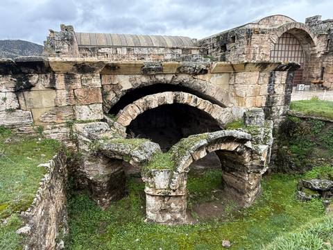       Ancient stone arches covered in moss at the ruins of Hierapolis.
  
