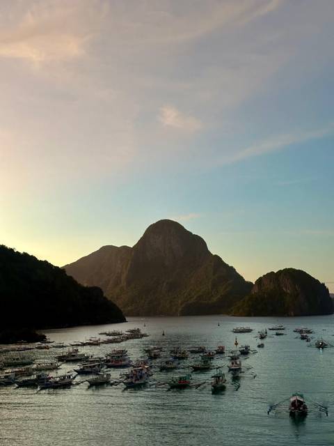       Silhouette of a rugged mountain against a pastel sky in the early morning light.
  