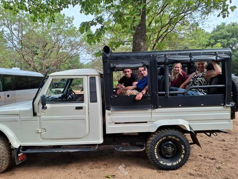       Tourists sitting in an open safari jeep, ready for an excursion.
  