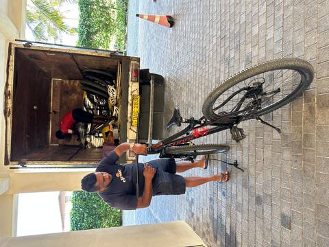       Technicians load and adjust bicycles from the back of a truck.
  