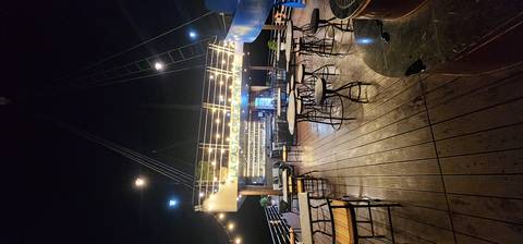       Nighttime upper deck sky bar of a Ha Long Bay cruise ship lit with string lights.
  