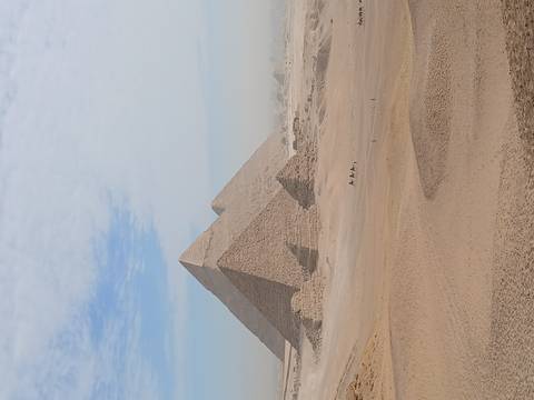       Crisp view of the Great Pyramid and neighbouring pyramid rising above golden desert.
  