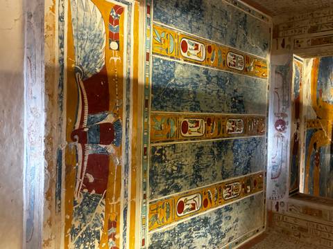       Colourful, well-preserved ceiling art inside an ancient Egyptian tomb passage.
  