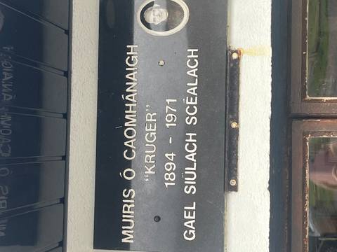       Close-up of an engraved memorial plaque with Gaelic and English text referencing ‘Kruger’.
  