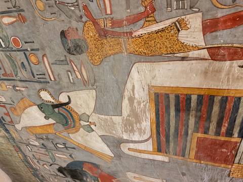       Colorful ancient tomb painting depicting Egyptian deities and hieroglyphs on plastered walls.
  