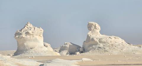       Chalk-white mushroom-shaped rock formations rise from the sandy plains
  
