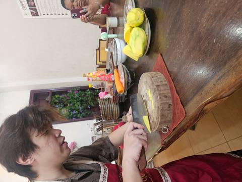       Cook slices mango on wooden board during hands-on kitchen class
  