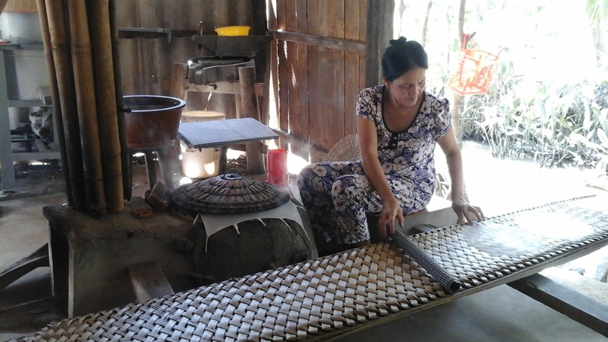       A woman working with traditional equipment indoors.
  