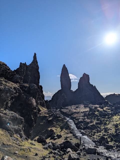       Iconic rock pinnacles of the Old Man of Storr silhouetted against blue sky
  