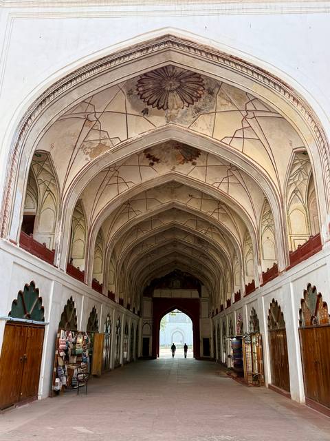       High arched ceiling with fading frescoes inside Humayun’s Tomb corridor
  