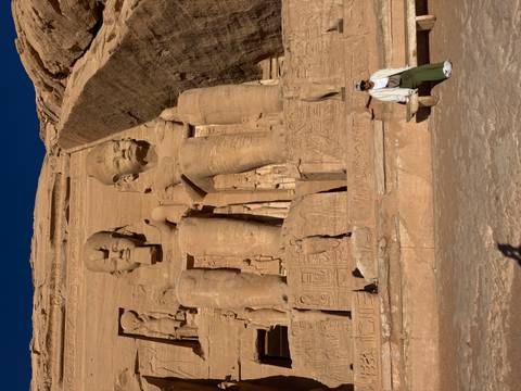       Gigantic seated statues of Ramses II dominate the Abu Simbel facade with a lone visitor for scale.
  