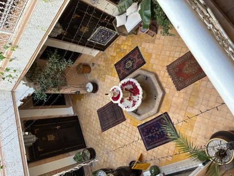       Courtyard fountain filled with rose petals in a traditional riad.
  