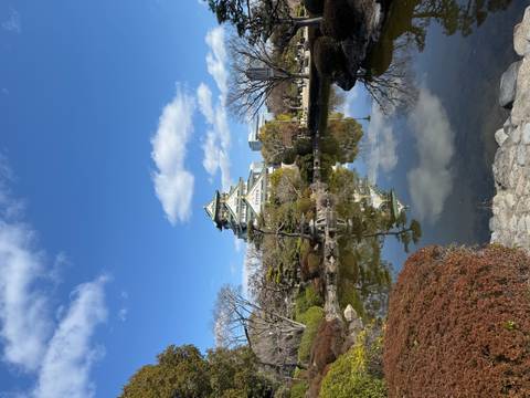       Majestic Osaka Castle surrounded by manicured gardens and reflecting perfectly in a tranquil pond.
  