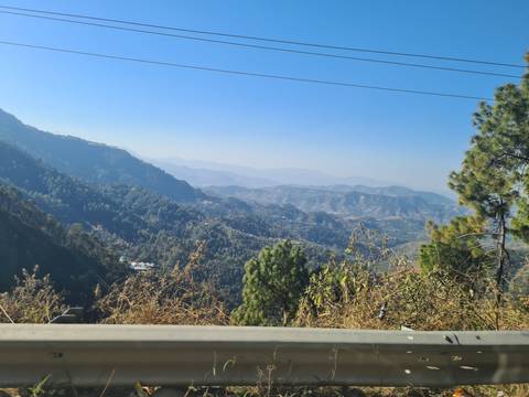       Layered mountain ridges fading into the hazy horizon with pines and valleys below.
  
