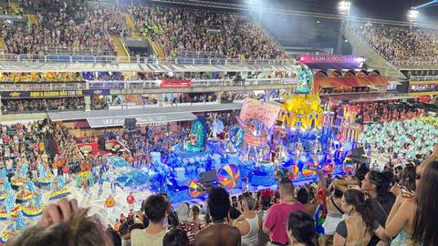       Vibrant parade floats and dancers fill the packed Sambadrome stands during Rio Carnival.
  
