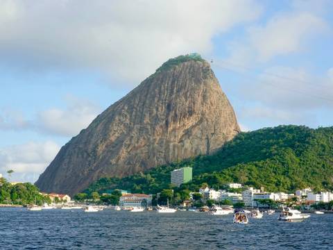       Close-up view of Sugarloaf Mountain rising above the bay with boats and city buildings below.
  