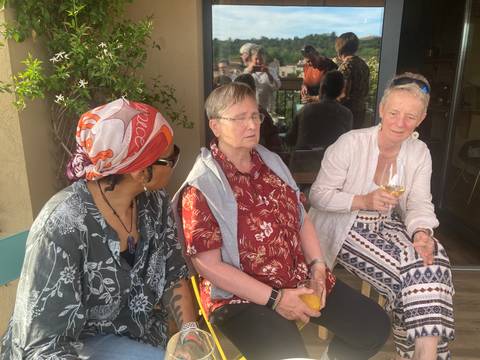       Three women enjoying drinks and conversation on a sunny terrace in rural Catalonia
  