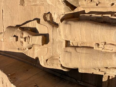       Close-up of colossal seated statue of Ramses II carved in sandstone at Abu Simbel
  