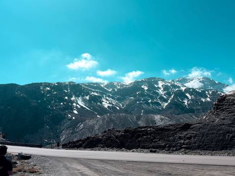       Snow-streaked peaks of the High Atlas Mountains under a brilliant turquoise sky.
  