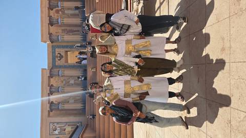       Travellers pose in ancient-Egyptian costumes on film-set steps flanked by painted columns and hieroglyphics.
  