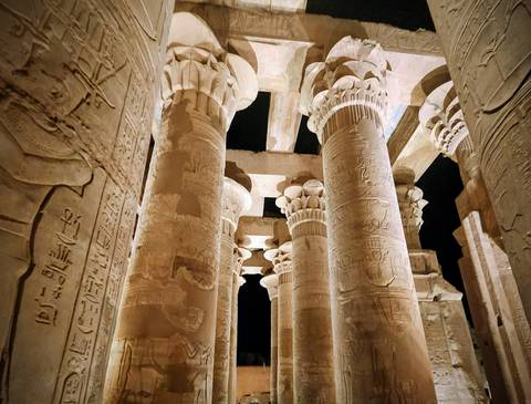       Dramatic night lighting illuminates the carved hieroglyphic columns of Kom Ombo Temple.
  