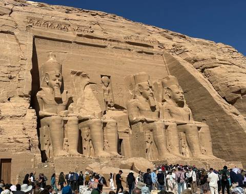       Colossal seated statues carved into the sandstone façade of Abu Simbel temple
  