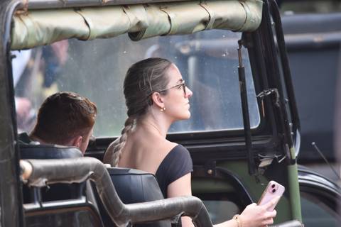      Young travellers ride in an open safari jeep observing wildlife through dusty windows.
  