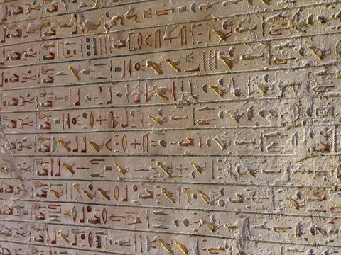       Close-up of colourful hieroglyph inscriptions carved into an ancient temple wall.
  