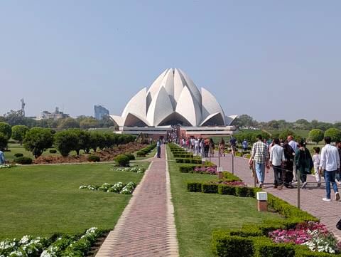       Visitors walking the formal gardens leading to the white Lotus Temple in Delhi.
  