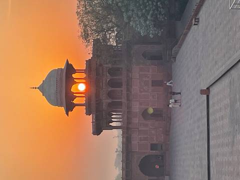       Rising sun perfectly framed within an ornate Mughal pavilion at dawn on the grounds of Agra Fort.
  