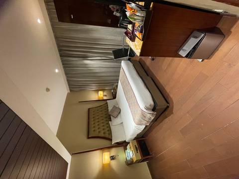       Modern hotel bedroom with tufted headboard, desk area and neutral tones.
  