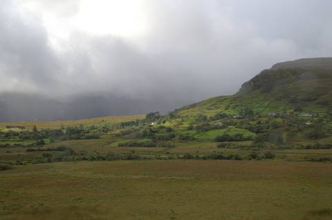       Misty Irish valley with patchwork farmland leading to a cloud-covered mountain ridge.
  