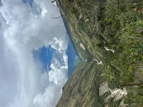       Deep green valley with a winding river and dramatic cloudscape above.
  