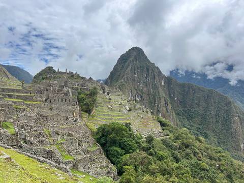       Iconic panoramic view of Machu Picchu ruins with Huayna Picchu peak looming behind.
  