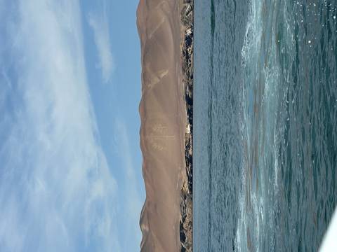       Sand hillside with the Paracas Candelabra geoglyph overlooking the Pacific Ocean.
  