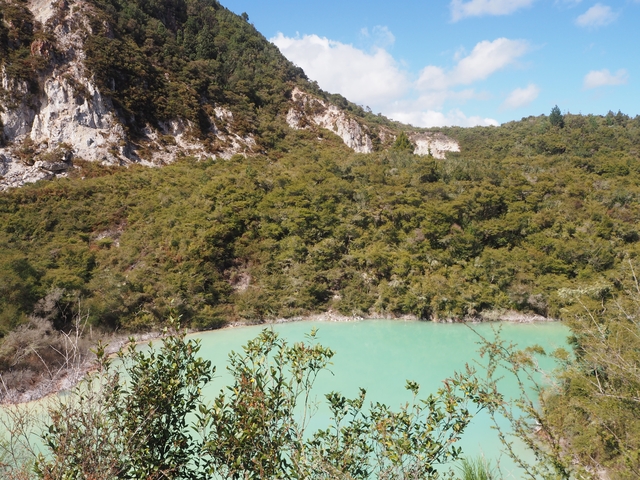 A turquoise lake in a lush mountainous area.