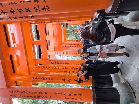       Crowds walk through the iconic orange Torii gate tunnels of Fushimi Inari Shrine.
  