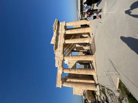       Classical marble columns and pediment of the Propylaea at the Acropolis under clear skies.
  