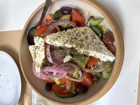       Traditional Greek salad with feta, tomatoes, cucumbers, olives and onions sprinkled with herbs.
  